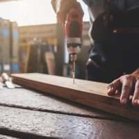 Carpenter working with equipment on wooden table in carpentry shop. woman works in a carpentry shop.